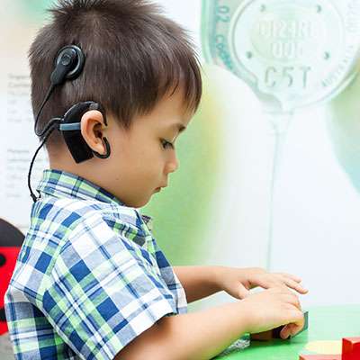 em bé trai đeo ốc tai